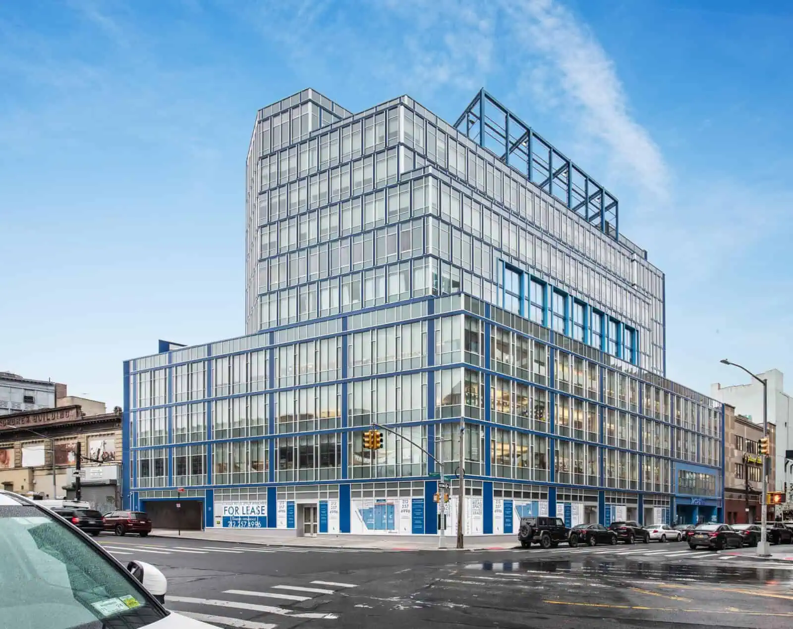 Modern glass office building with multiple floors and urban surroundings.