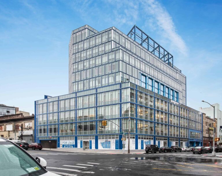 Modern glass office building with multiple floors and urban surroundings.