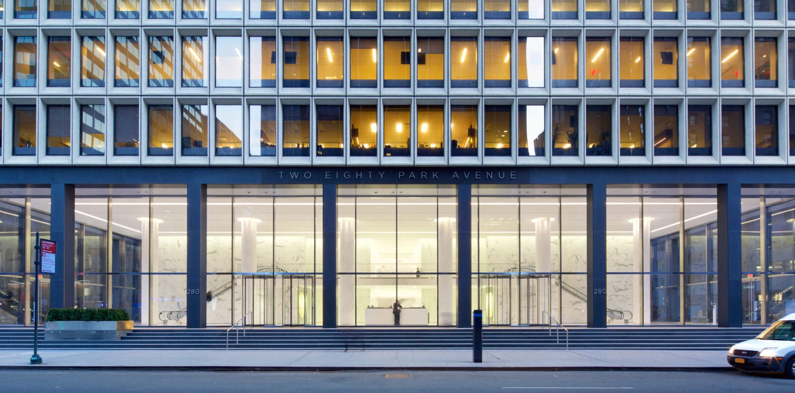 Modern office building with YKK branding and large glass windows.