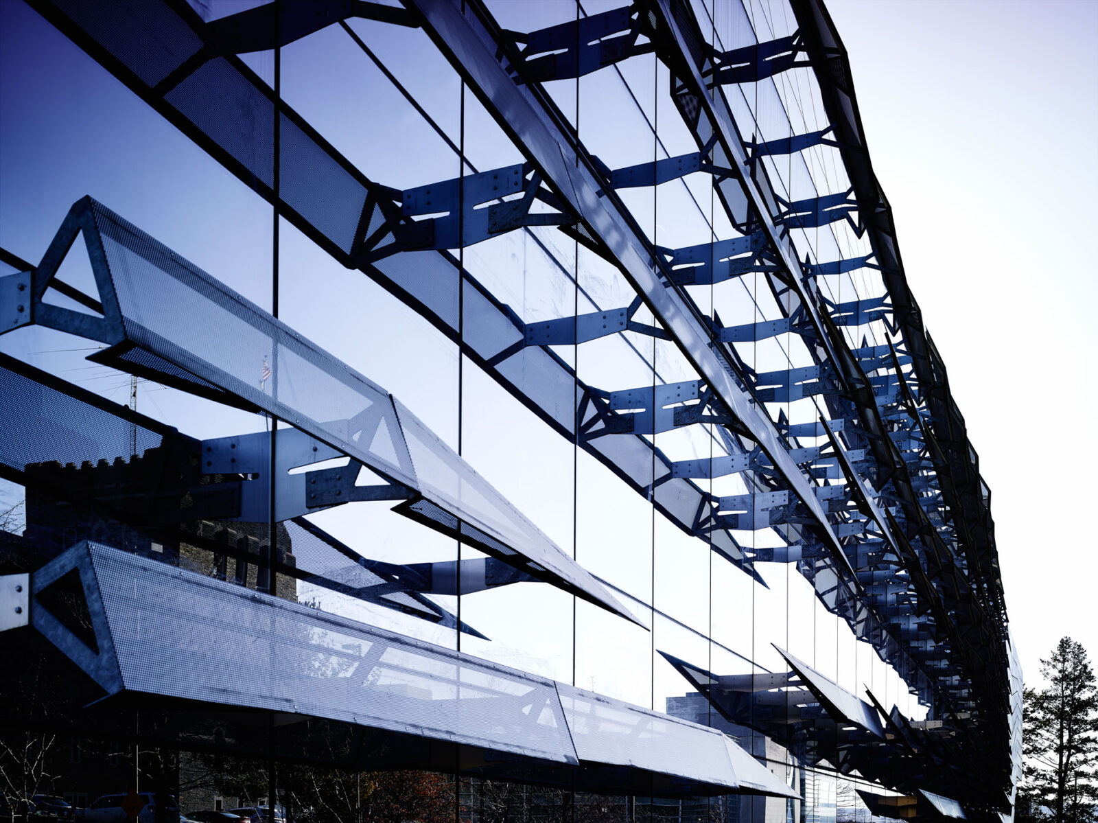 Contemporary glass building with reflective windows and structural design.