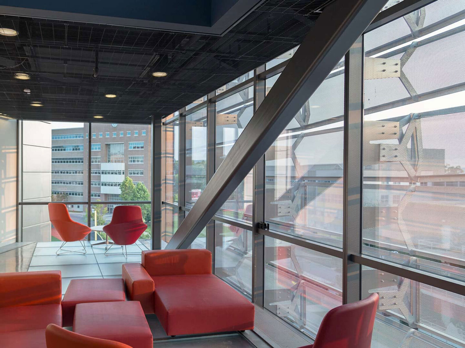 Contemporary office space with large glass windows and red seating.
