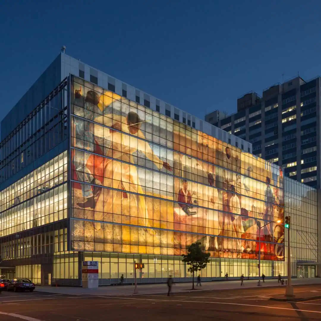 Modern YKK building featuring a large artistic glass mural in an urban setting.