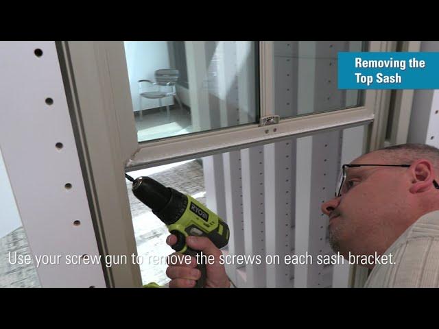 Removing the top sash from a window with a screw gun.