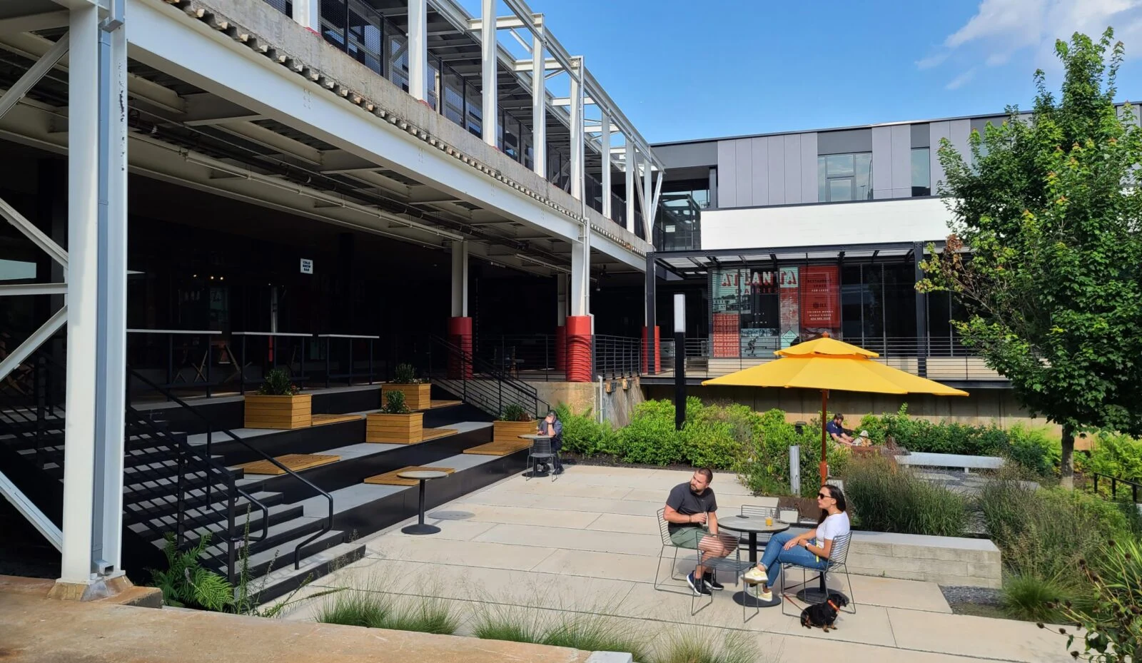 A lush outdoor seating area with modern architecture and greenery.