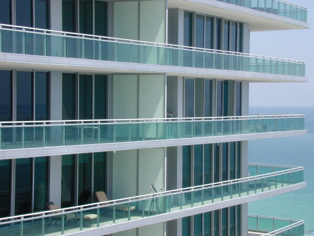 Modern glass balcony on a high-rise building overlooking the ocean, YKK windows.