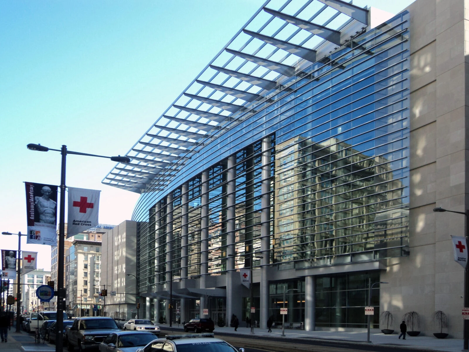 YKK modern glass building with reflective facade in an urban cityscape.