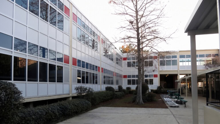 YKK building exterior at Archbishop Rummel High School with modern windows and a.