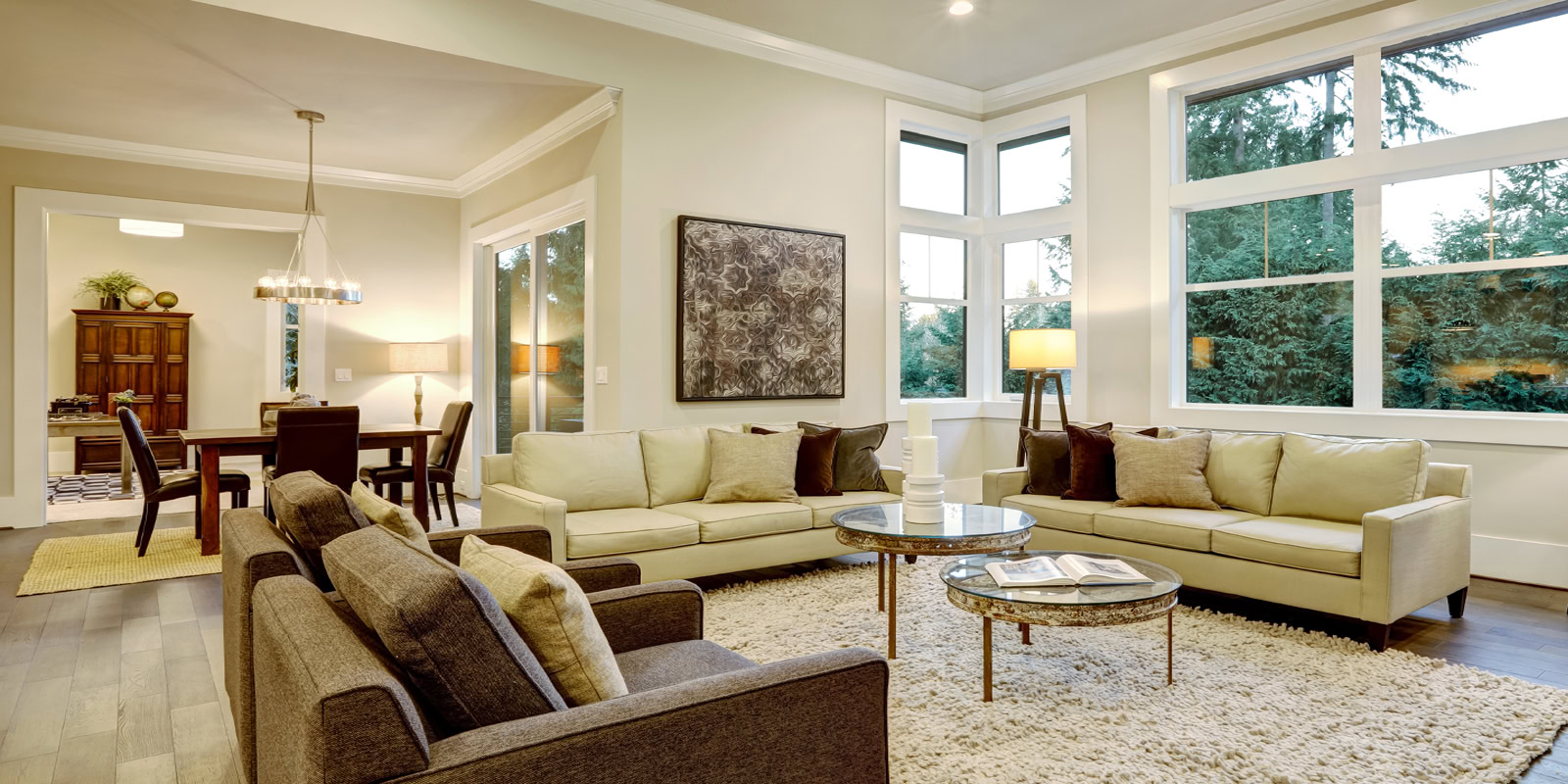 Spacious living room with large windows, cozy sofas, and natural light.