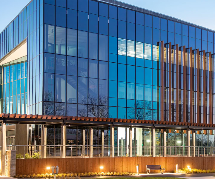 Contemporary glass office building with YKK branding and modern architecture.