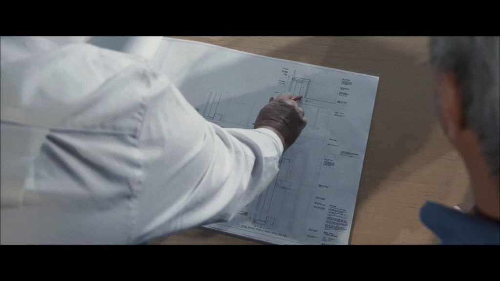 A detailed technical drawing or blueprint being reviewed by a person in a profes.
