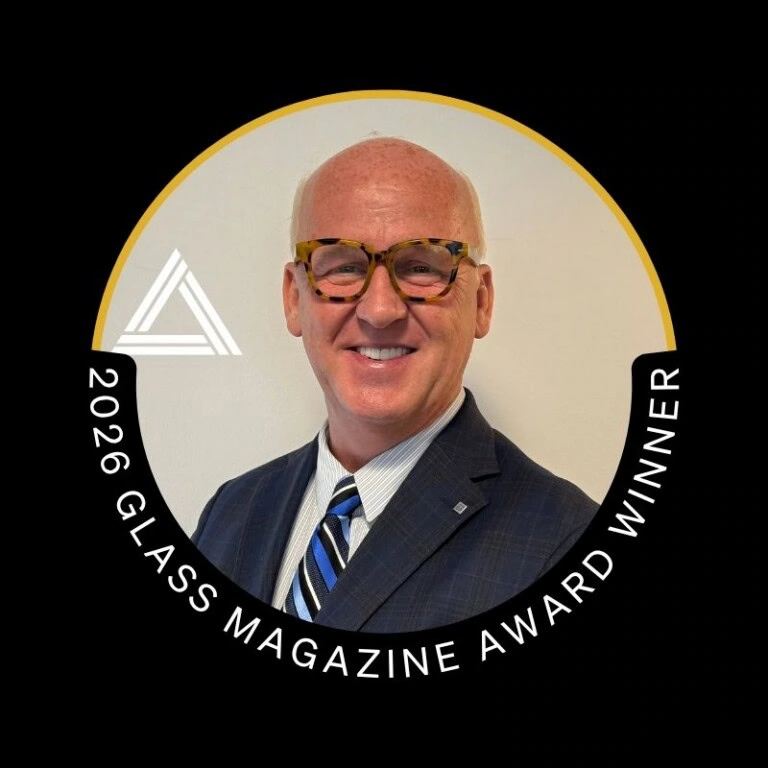 2026 Glass Magazine Award Winner badge with smiling man in suit.
