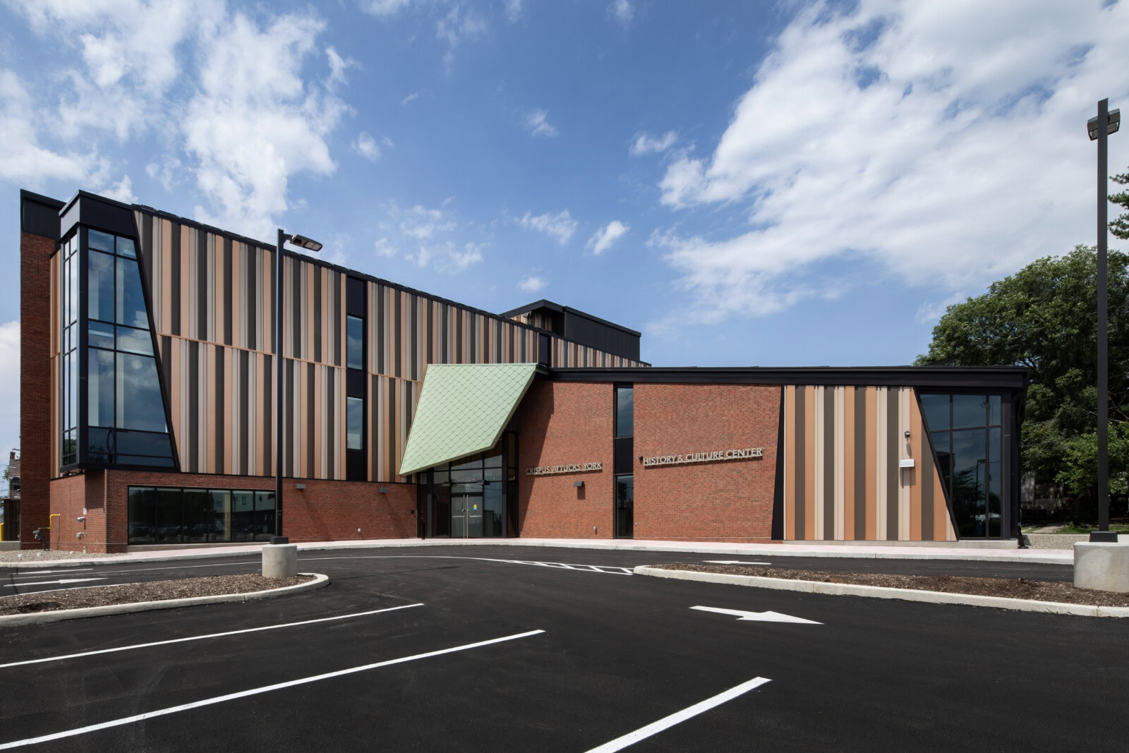 Modern YKK building with colorful facade and parking lot.
