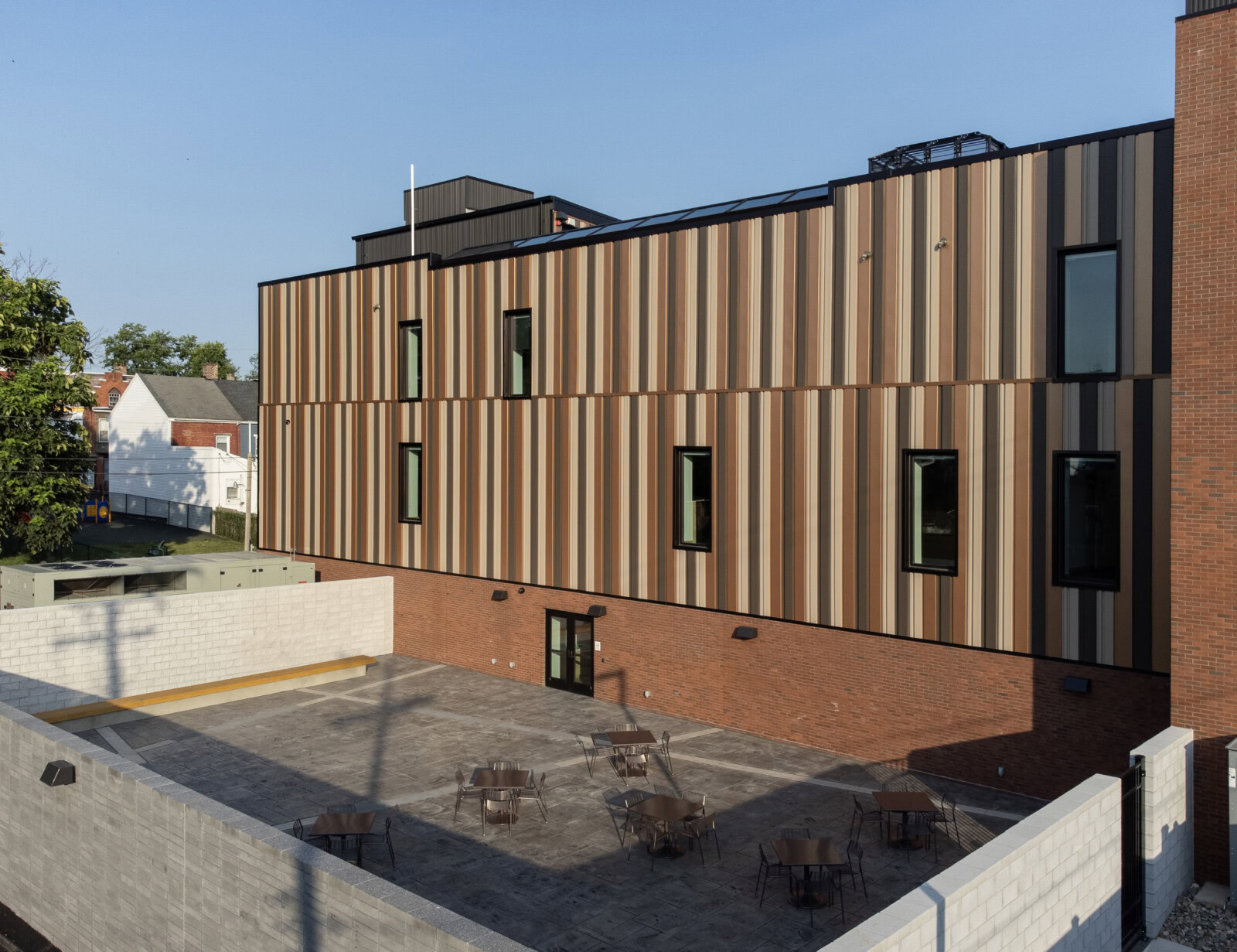 Contemporary building with wooden exterior and rooftop terrace.